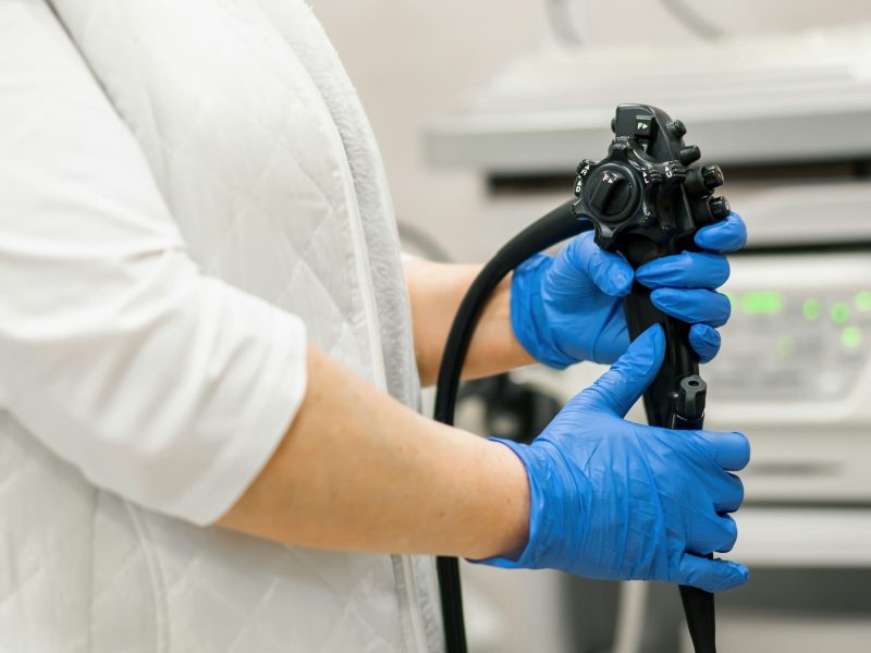 Close-up doctor's gloved hand with endoscope during diagnostic gastroscopy or colonoscopy in clinic